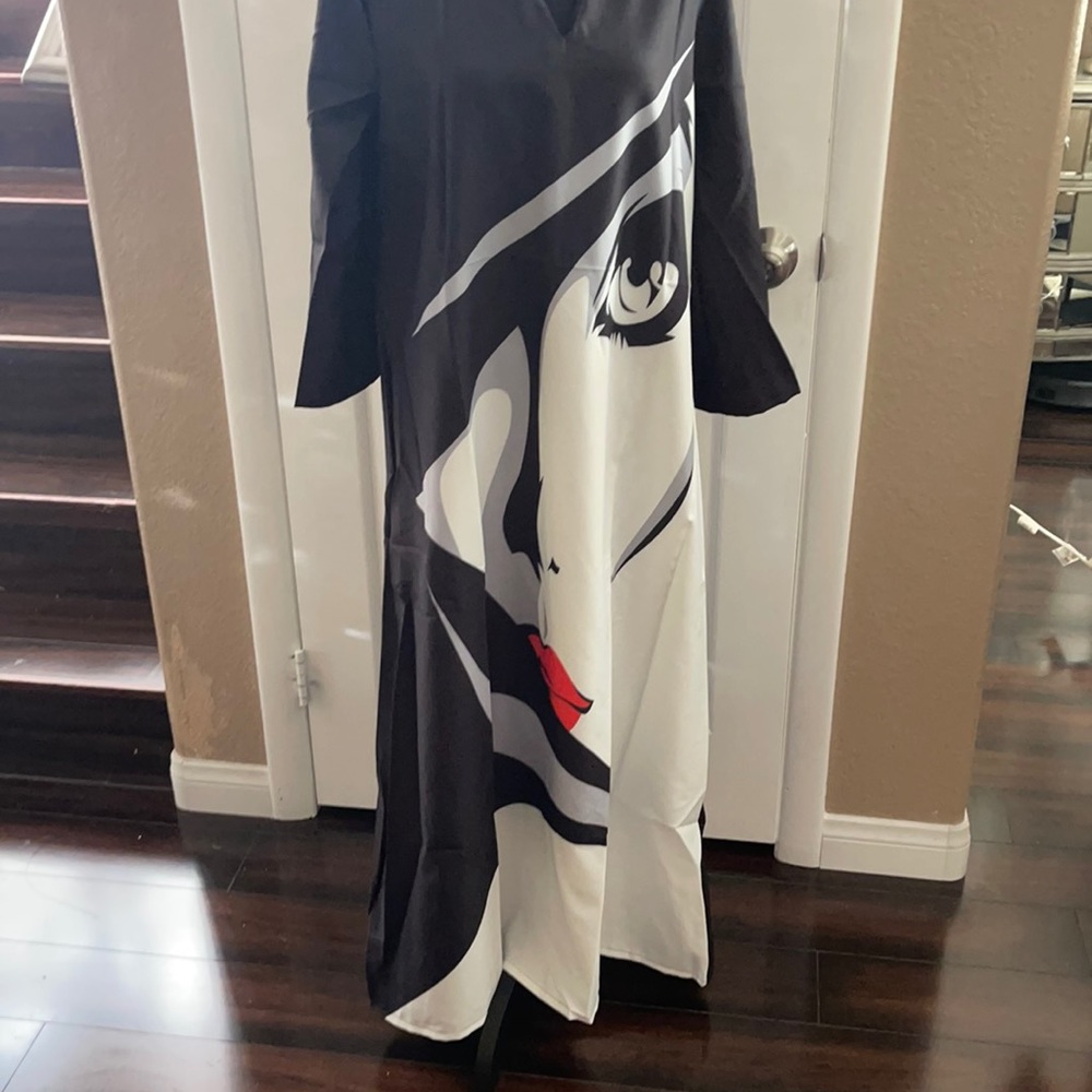 A woman’s dress size large very unique with a woman’s face on the front new